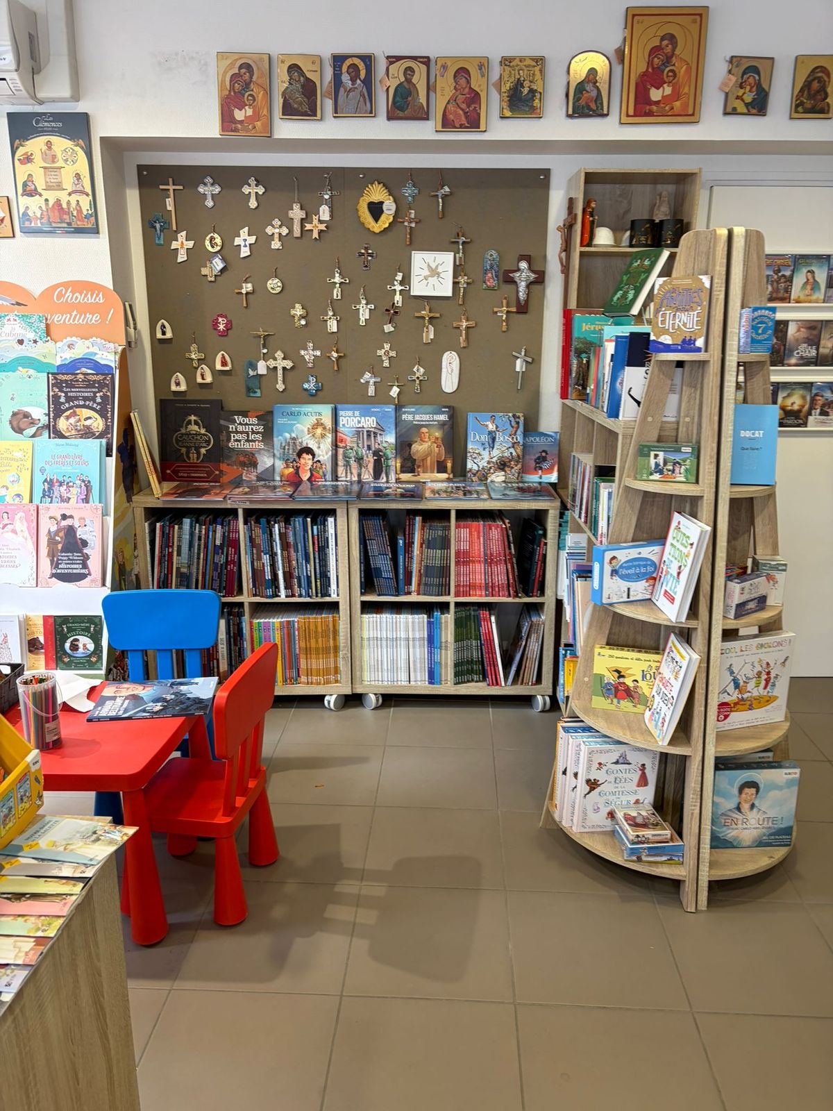 Coin enfants avec petite table, mur de croix et icônes
